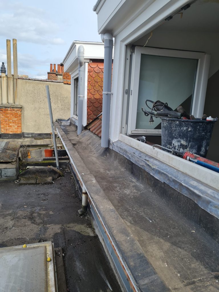 Artisan Democoup réparant un chien-assis à Bruxelles Woluwe-Saint-Lambert, travaux en cours sur la lucarne.