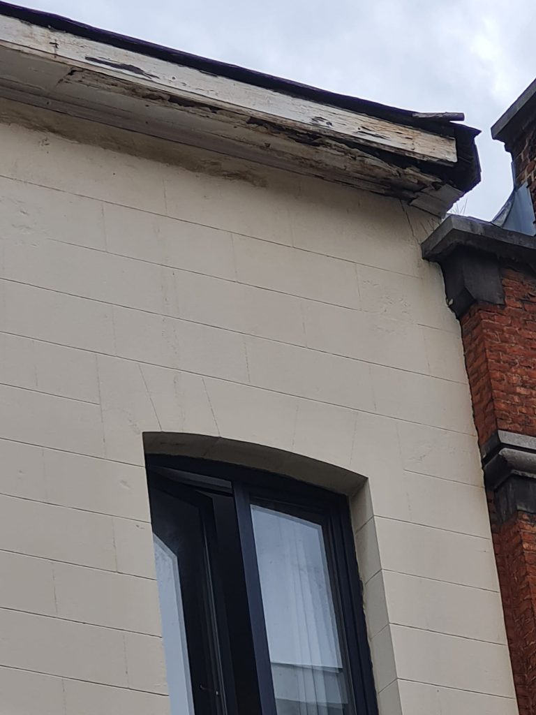 Corniche endommagée à Bruxelles avant réparation, montrant fissures et dégradations