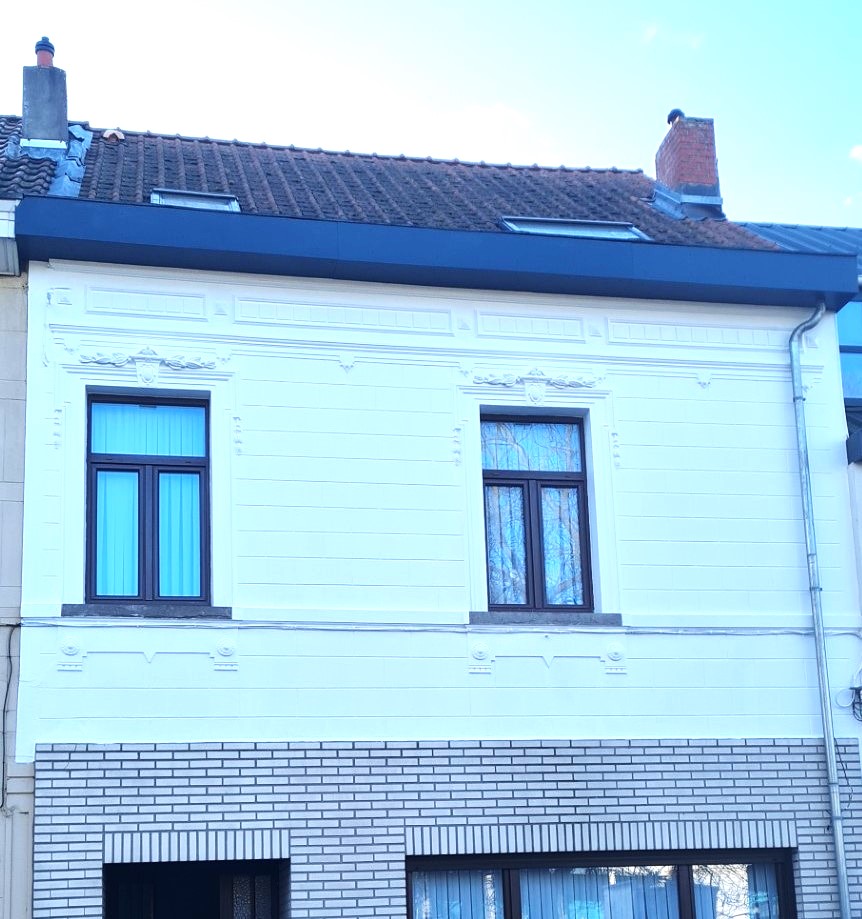Corniche en fibre-ciment rénovée et façade fraîchement peinte à Uccle par Democoup, aspect propre et moderne.